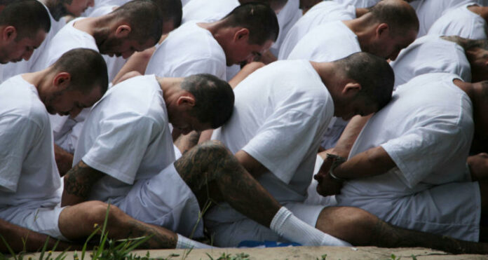 Mara Salvatrucha (MS-13) gang members wait to be escorted upon arrival at the maximum-security jail in Zacatecoluca,